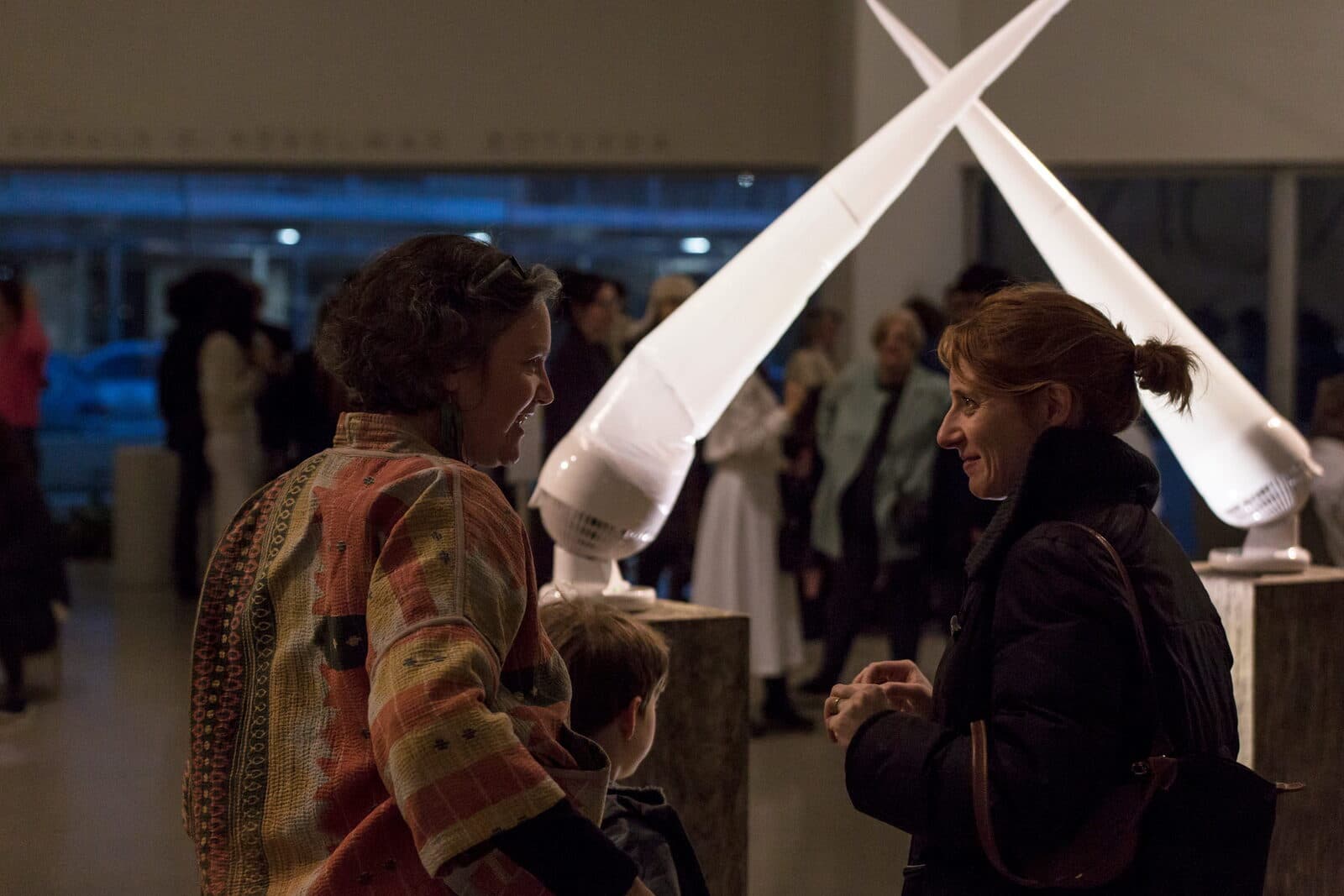 Visitors talking beside two crossed inflatable forms